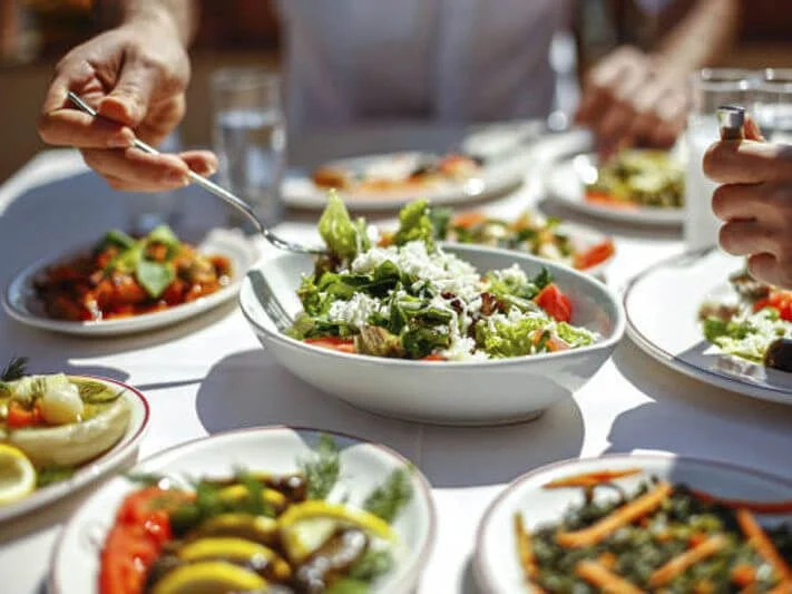 couple eating lunch with fresh salad and appetizers